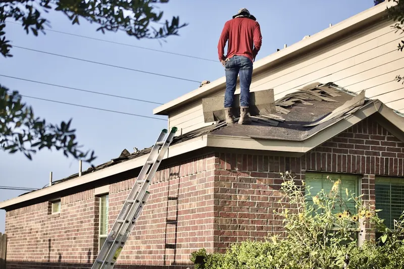 Professional roofer working on a residential roof in West District